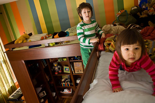 Double loft beds with children playing and under bed storage shelves